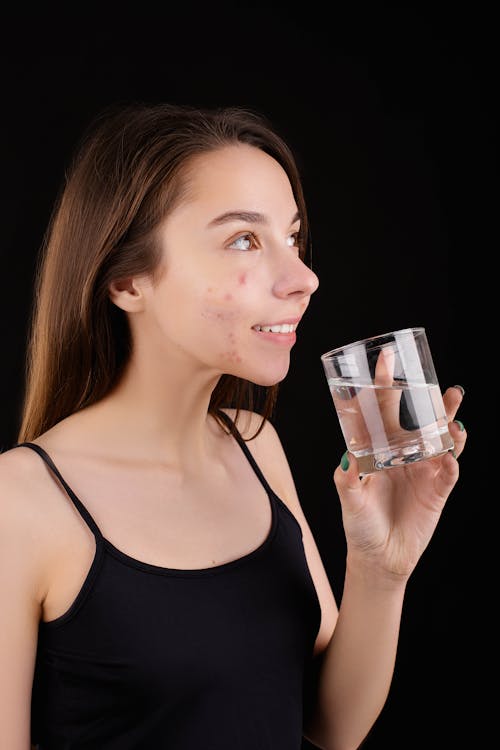 Free A Smiling Teenager Holding a Glass of Water Stock Photo