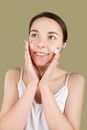 Smiling Teenager Applying a Facial Cream on Her Face