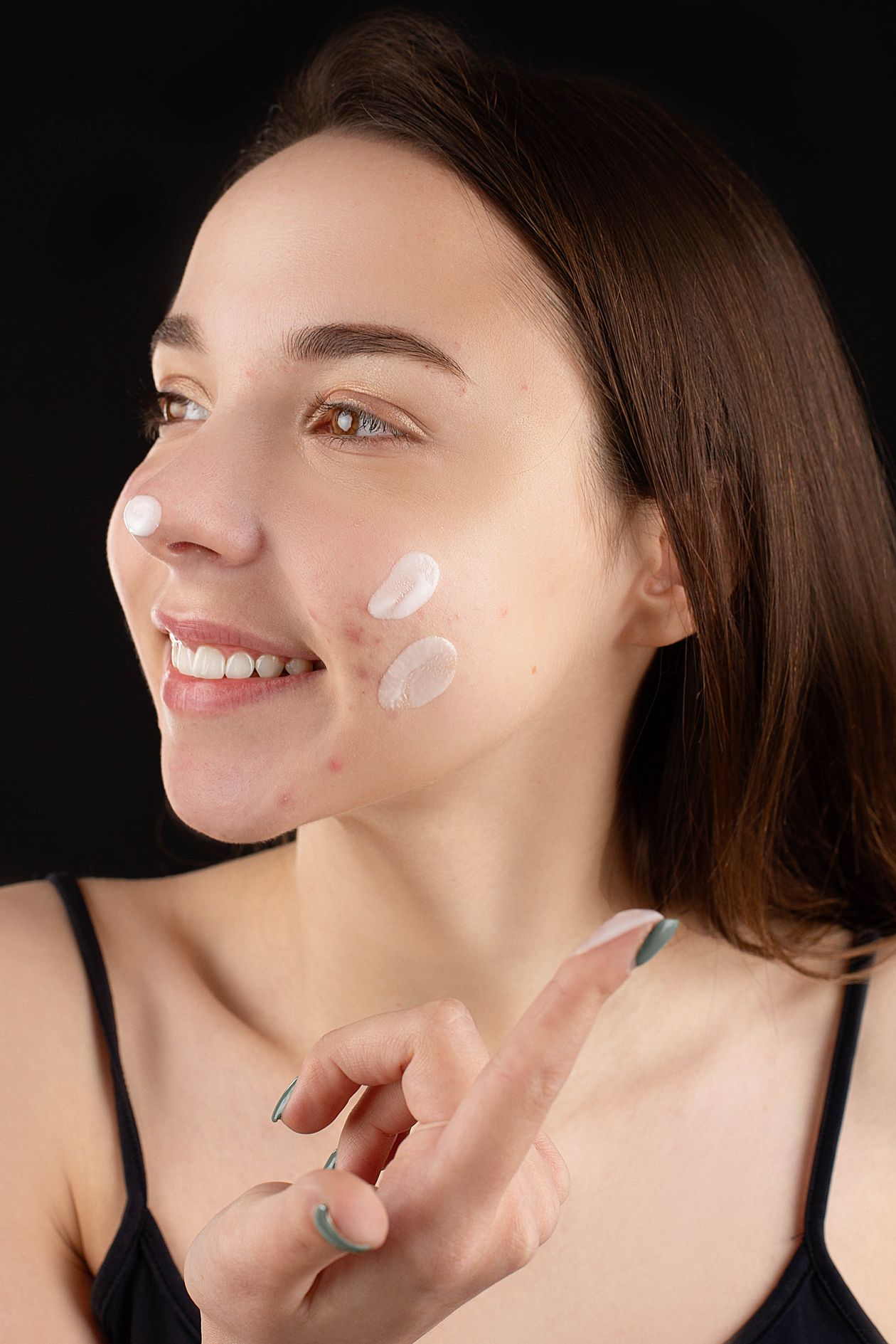 Joven aplicando crema facial para cuidar la piel