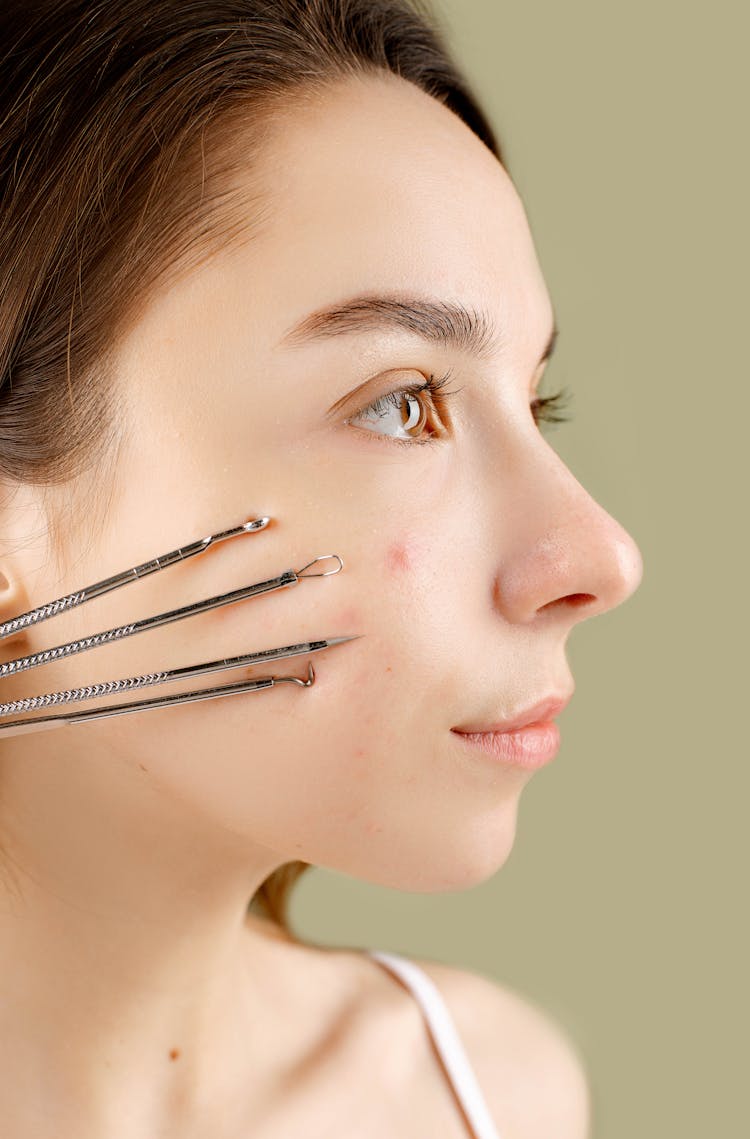 Woman With Variety Of Cosmetic Tools On Face