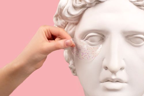Free Sculpture head bust with under eye patch applied, capturing skincare concept. Stock Photo