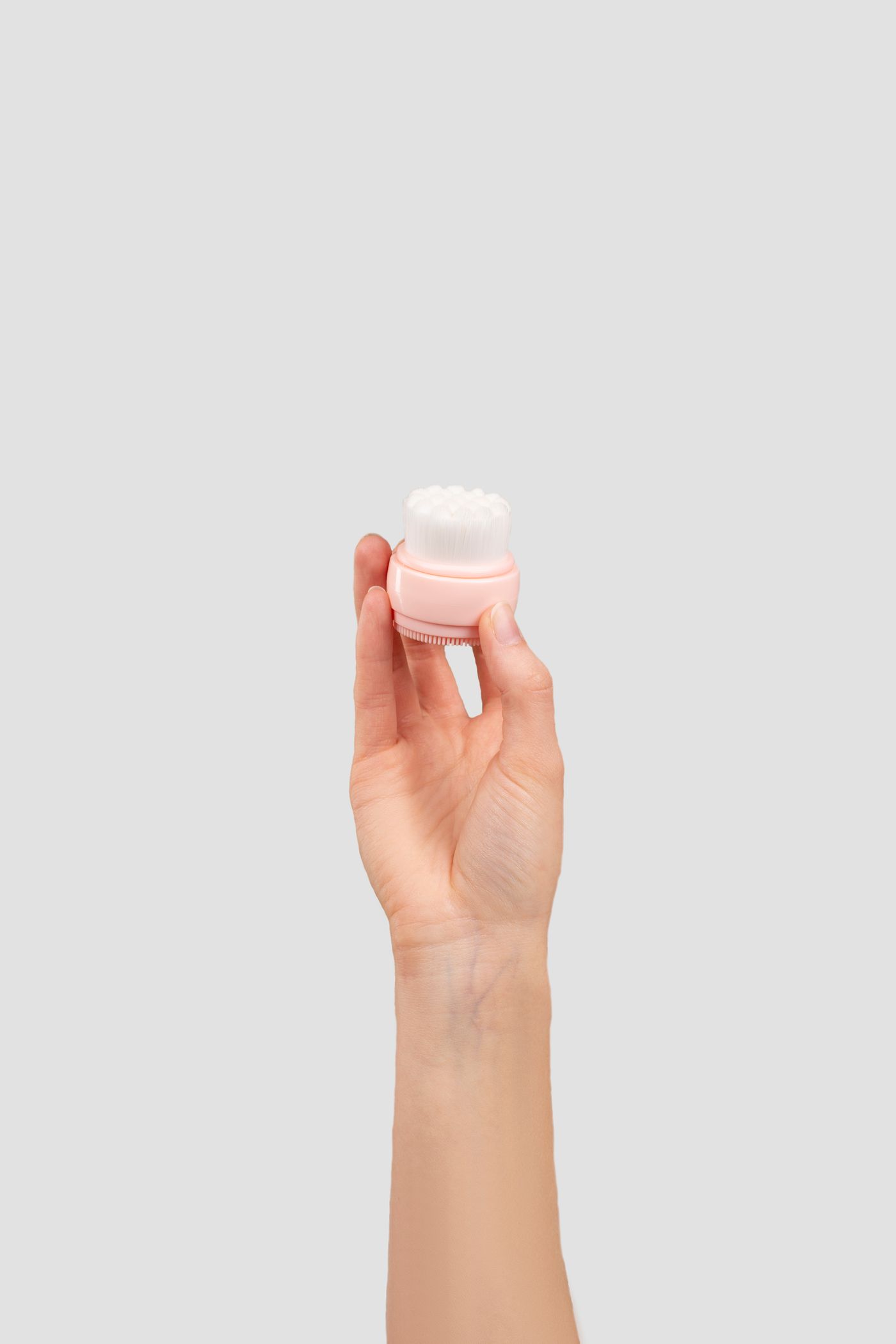 Hand holding a facial cleansing brush for a gentle skincare routine