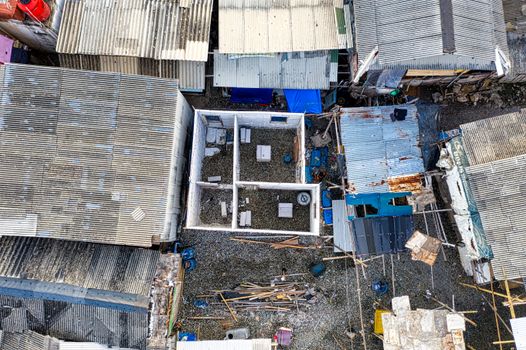 Top view of rooftops and urban structures in Jakarta, Indonesia, showcasing corrugated materials and construction details.