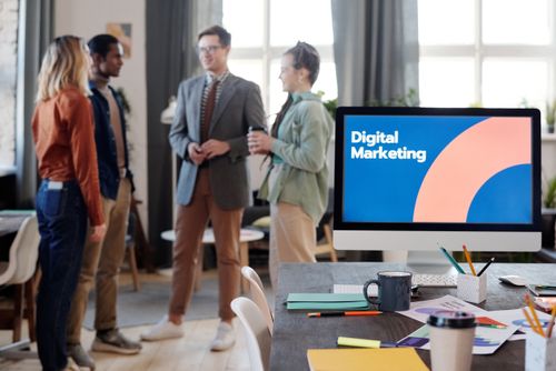 Free A diverse team collaborates in a modern office setting, discussing digital marketing strategies. Stock Photo