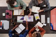 People Sitting Around Table With Papers