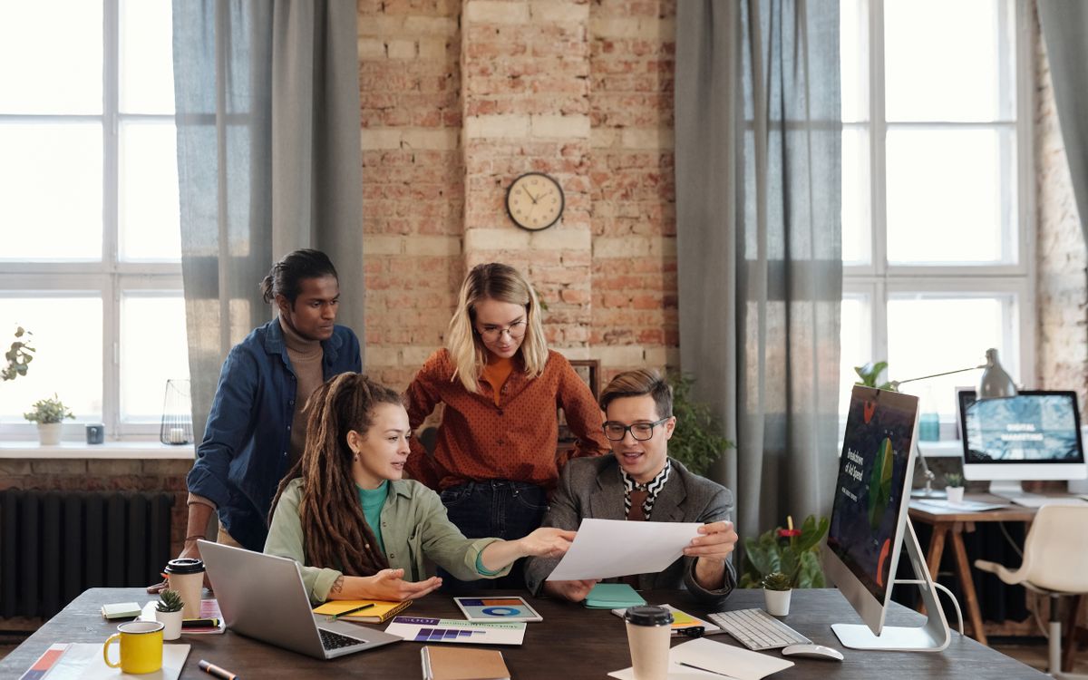 A diverse team of young professionals working on a business strategy in an urban office setting.