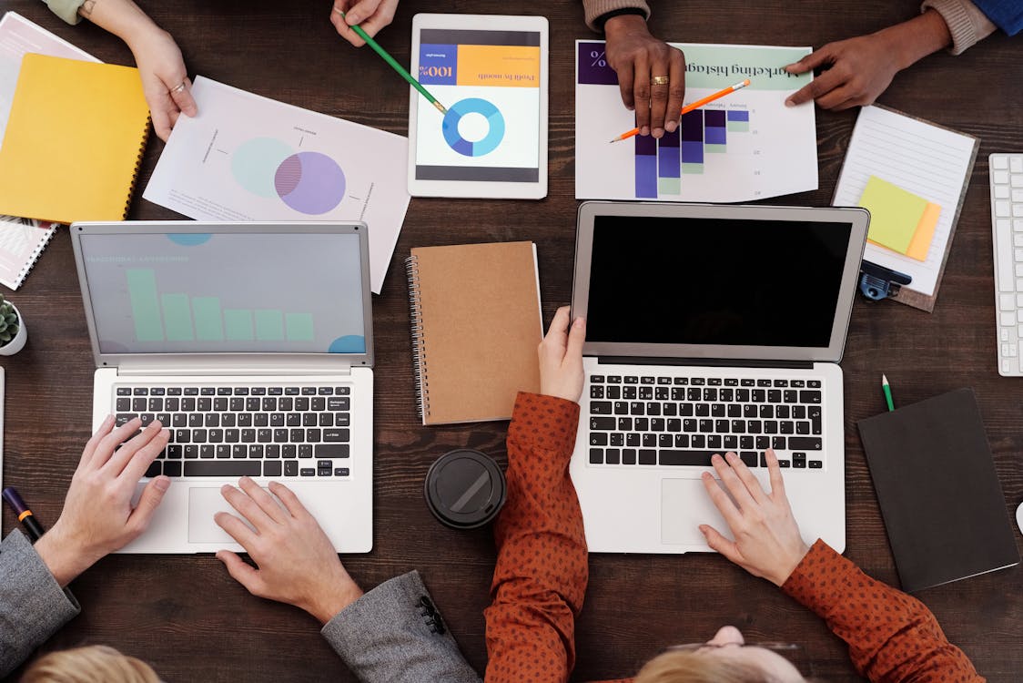 Free A Group of People with Graphs and Pie Charts on Table Stock Photo