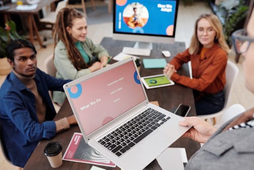 People Listening to the Man Holding a Laptop