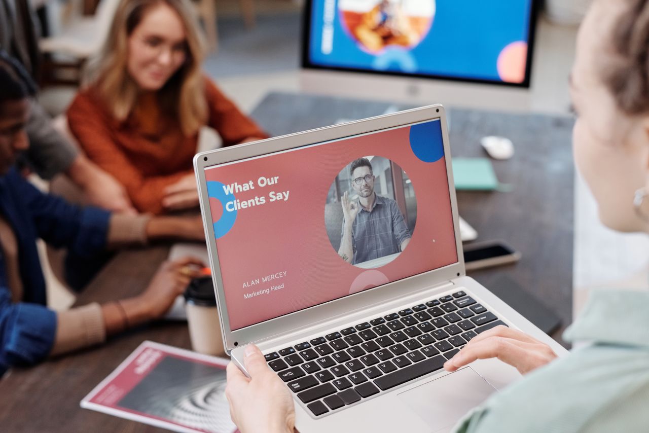 Professional team reviewing a digital product on a laptop in a real office