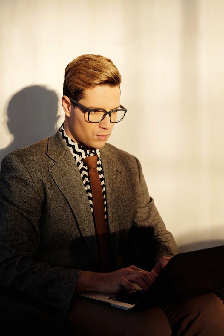 Man In Business Suit Using A Laptop