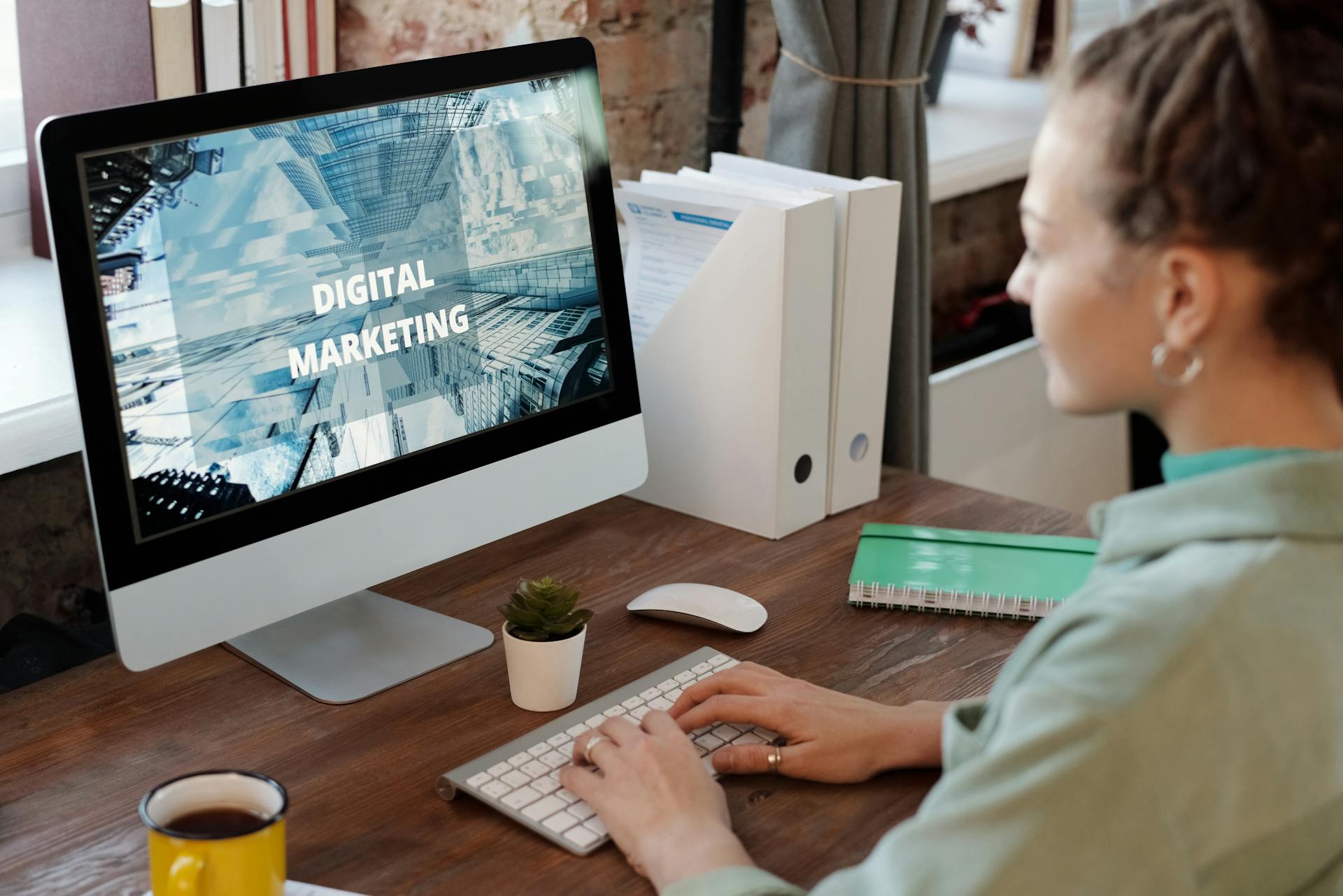 Professional woman engaged in digital marketing work at her home office desk.