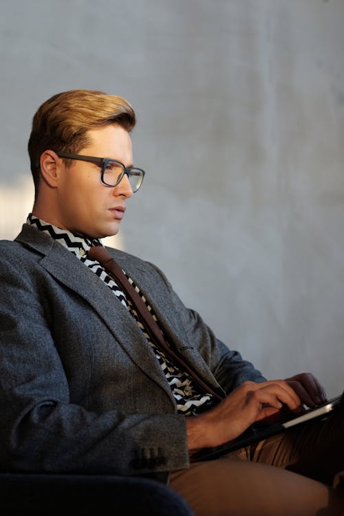 A Man in Suit and Wearing Eyeglasses