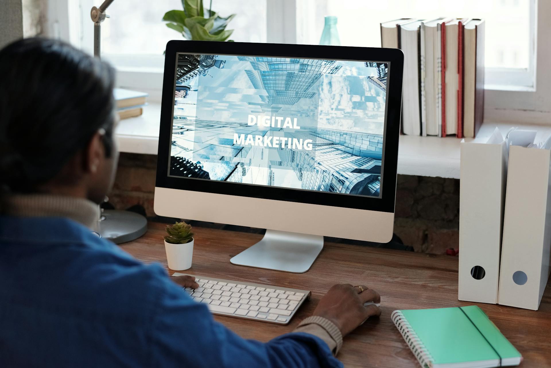 A person working on digital marketing at a well-organized workspace with a computer.