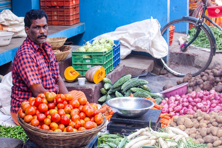 A Man Selling Vegetables In The Market