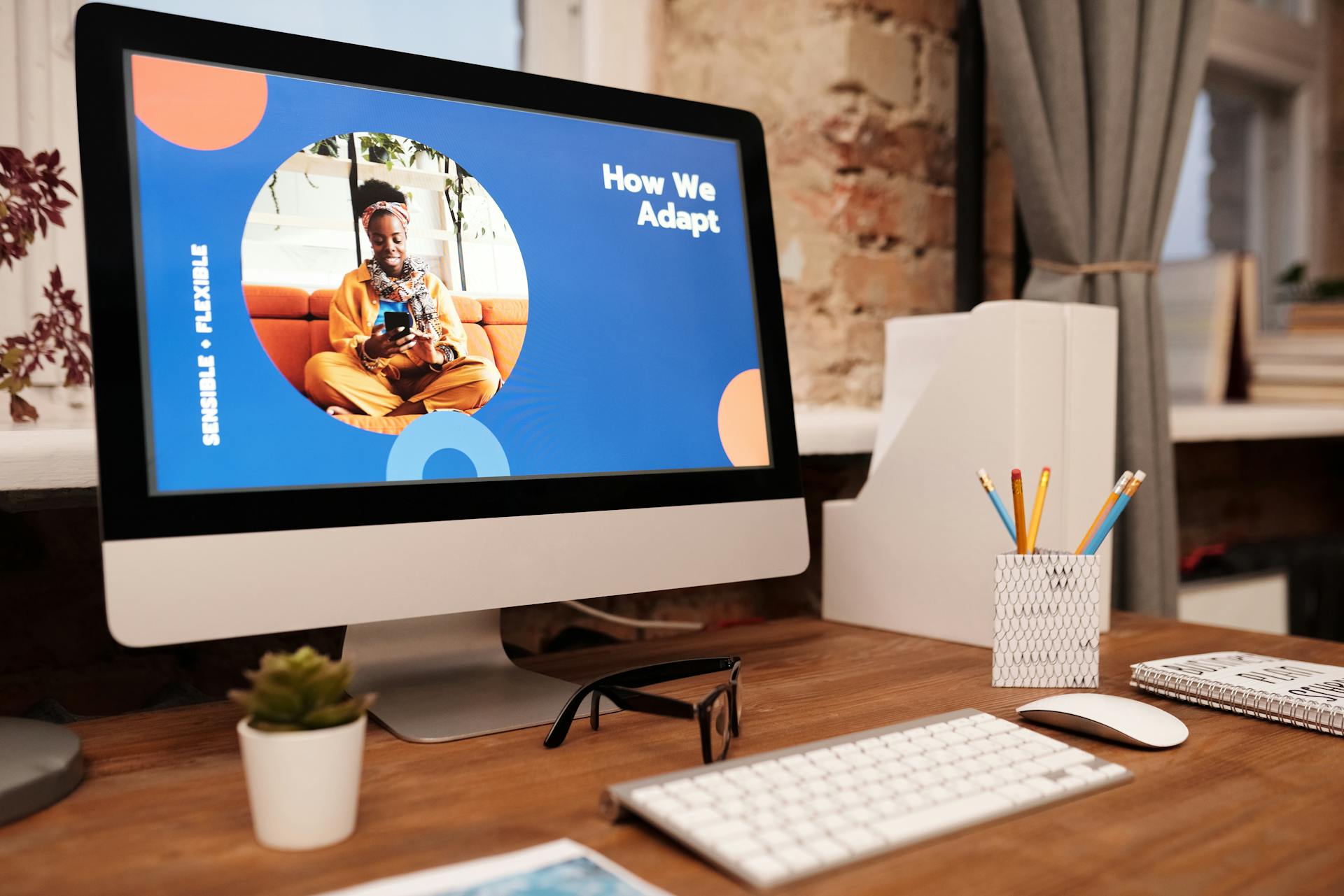 A stylish office desk setup with a computer screen displaying a digital presentation in a cozy home office.