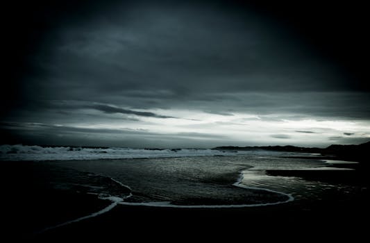 A moody seascape with dramatic clouds over a South African beach at sunset, creating a tranquil and scenic view.
