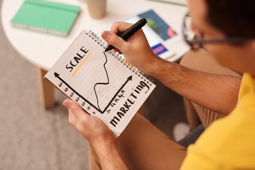 Man Drawing a Graph on Notebook