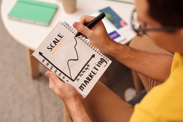 Man Drawing A Graph On Notebook