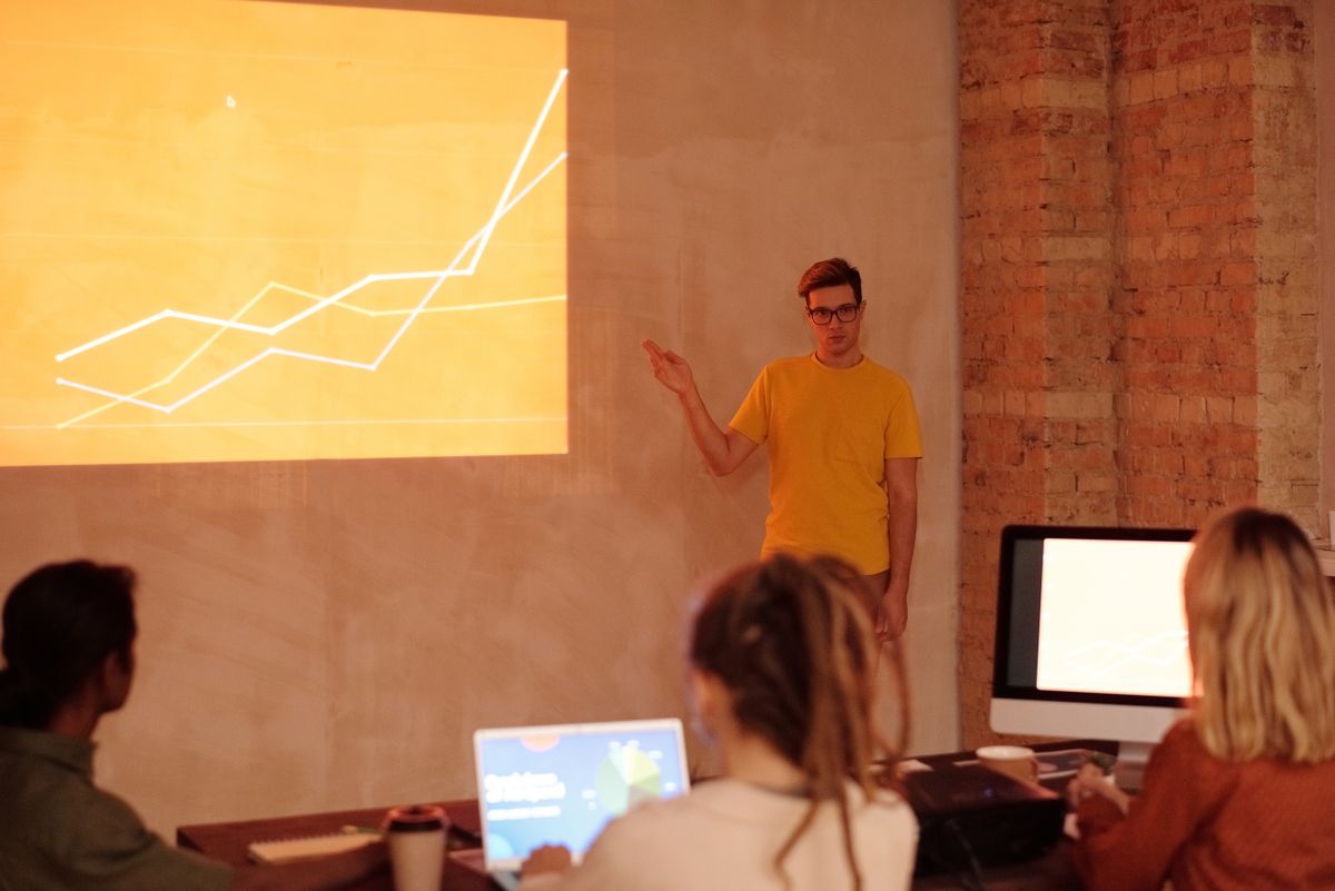 A professional walking a team through improved data slides in an office meeting
