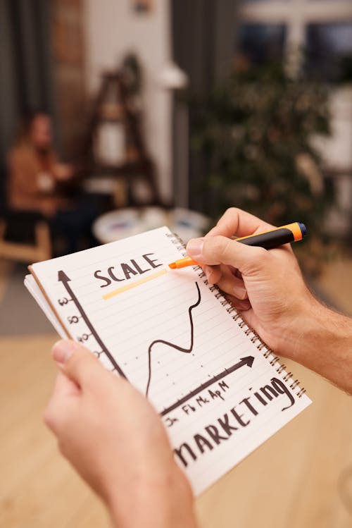 Person Drawing on a Notebook