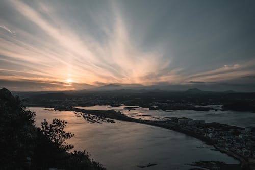 Body of Water Near Trees during Sunset