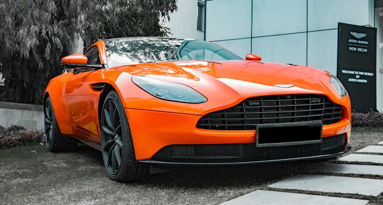 Orange Aston Martin Parked Outside A Building