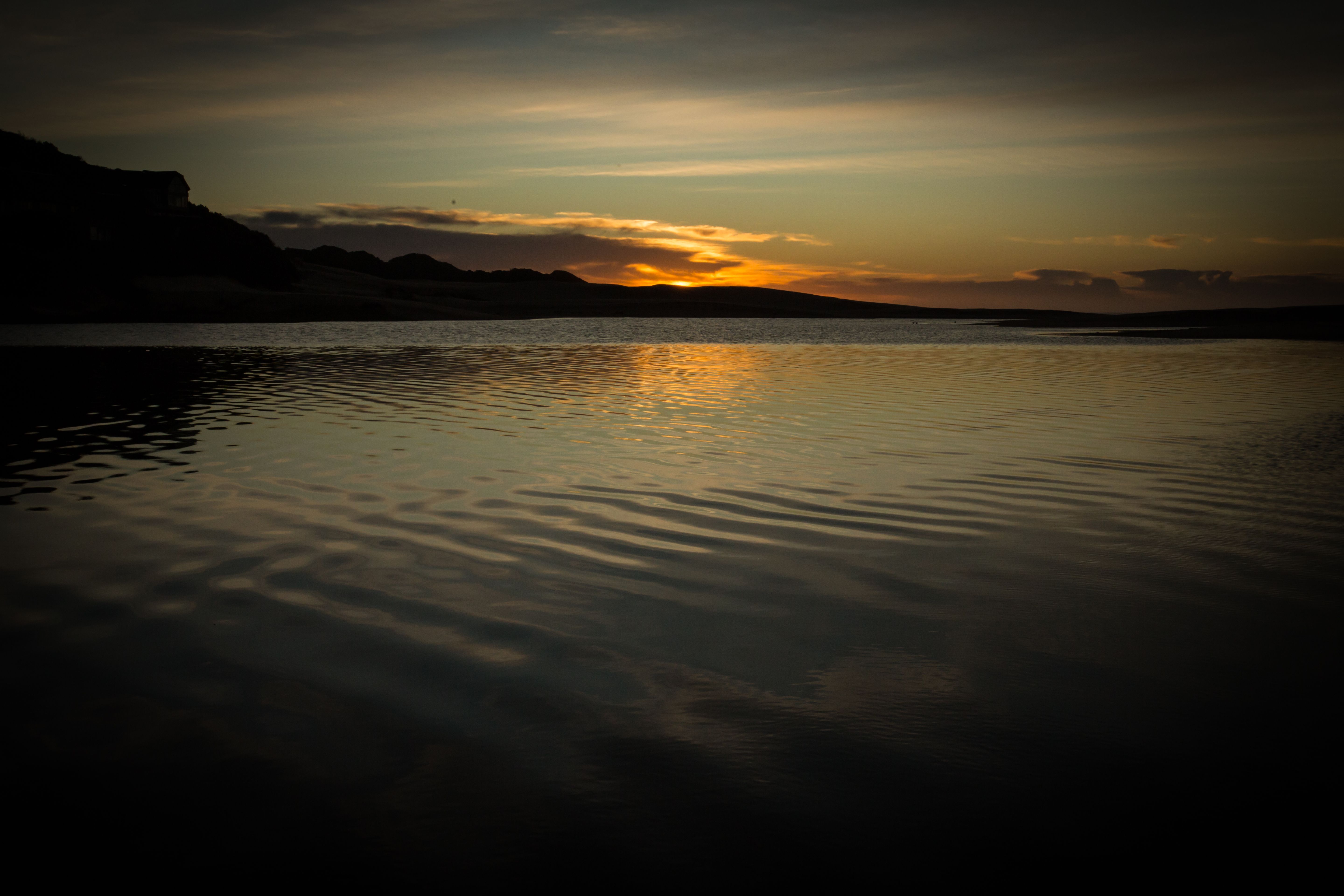 Calm rippling water of lake in golden sunset · Free Stock Photo