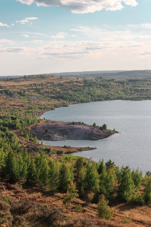 Free A breathtaking aerial view of a lake surrounded by vibrant green trees in Bashkortostan, Russia. Stock Photo