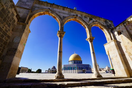 Low Angle View of Arches and Gold Cupola against Blue Sky