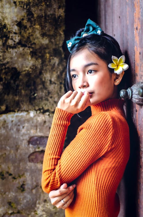 Girl in Orange Sweater Wearing Blue and White Floral Ribbon