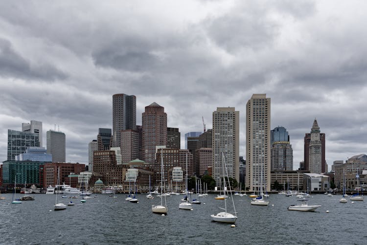 White Boats On Body Of Water Near City Buildings