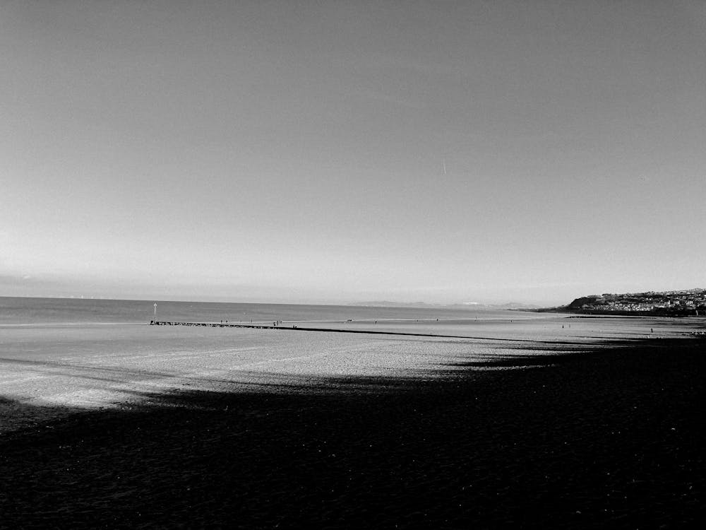 Sea waves rolling on sandy shore in daylight