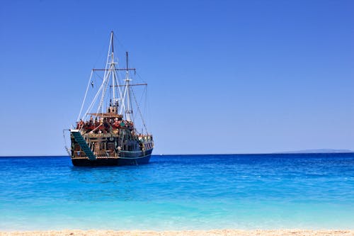 Free Brown Ship on Sea Under Blue Sky Stock Photo