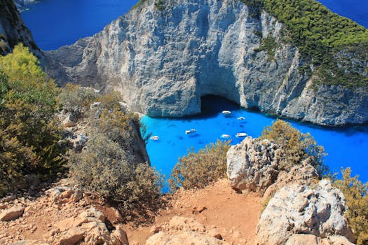 A stunning aerial view of Navagio Beach with turquoise waters, cliffs, and boats in Zakynthos, Greece.