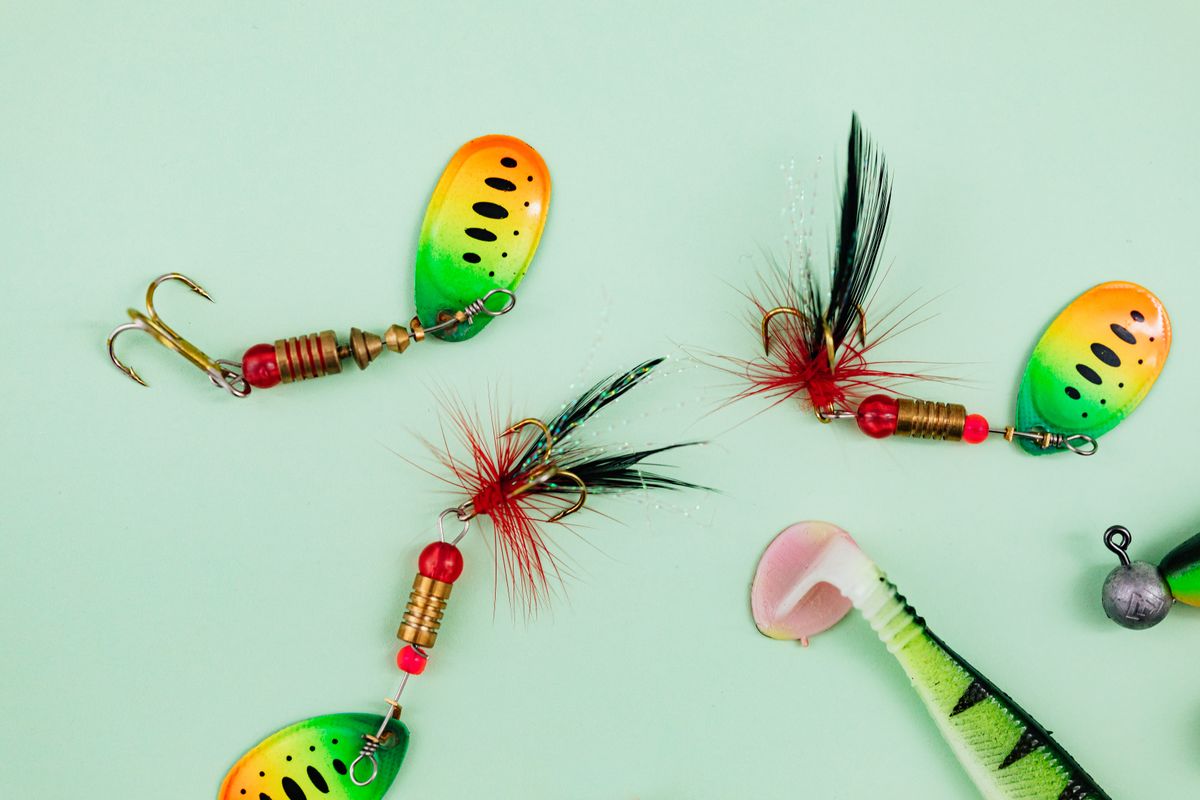 Colorful fishing lures arranged on a green surface