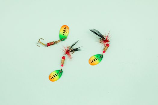 Vibrant fishing lures arranged on a pale green surface, ideal for anglers.