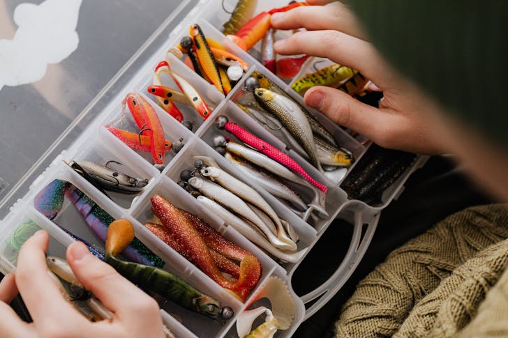 Assorted Fishing Lures Arranged on a Plastic Container