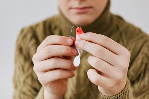 Person Holding a Hook and a Fishing Lure