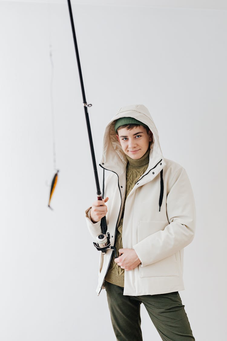 Smiling Man In White Jacket Holding A Fishing Rod With Bait