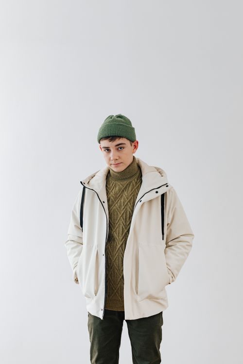 Free Portrait of a person in winter attire with beanie and turtleneck against a white background. Stock Photo