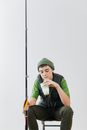 Man in Green Knit Cap and Green Shirt Sitting on Chair