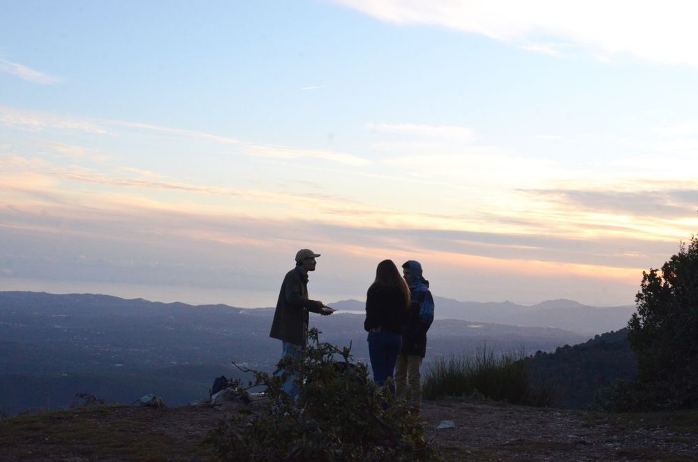 Friends standing on a mountain at sunset