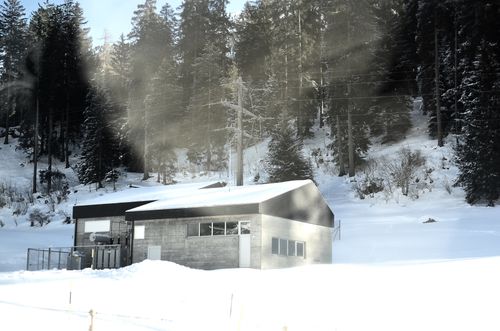 Free A secluded cabin in a snowy forest in Switzerland showcasing winter beauty and tranquility. Stock Photo