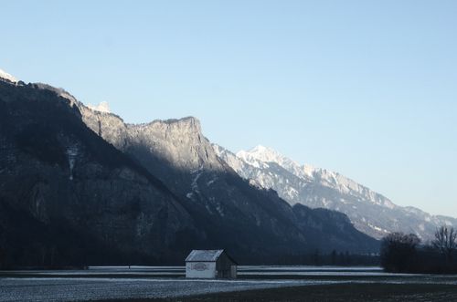 Free Tranquil winter scene in Swiss Alps with snowy mountains and a solitary hut. Stock Photo