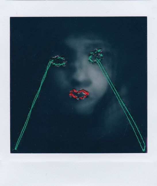 Artistic portrait with embroidered accents over facial features creating a conceptual look.