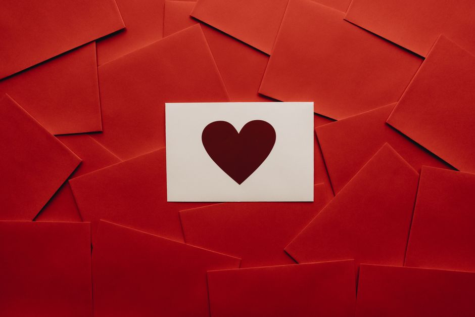 Red envelopes and a white card with a heart, perfect for Valentine's Day themes.