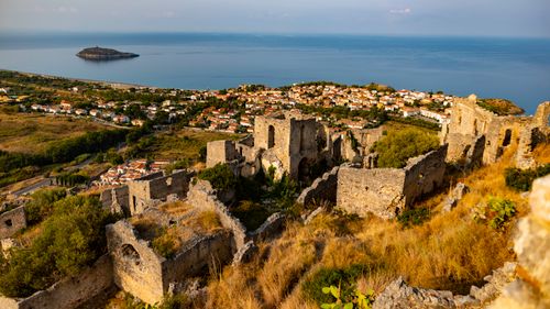 Free Capture of ancient ruins overlooking a coastal town and sea during daytime. Stock Photo