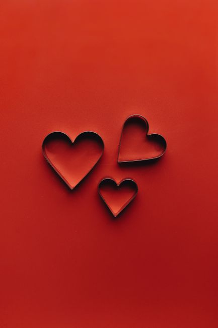 Three heart-shaped objects on red background, perfect for Valentine's Day themes.
