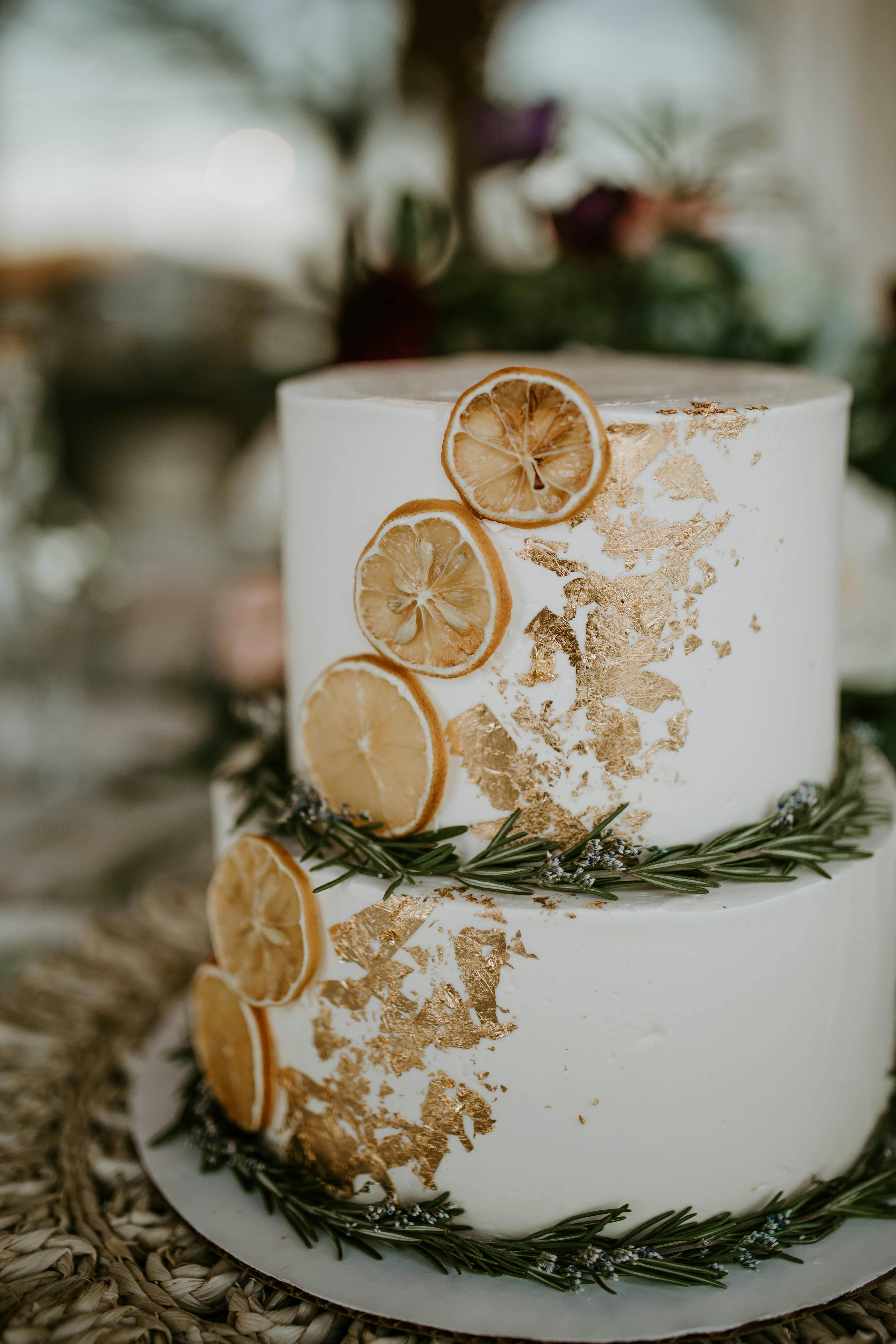 wedding cake decorated with branches of rosemary and dried orange