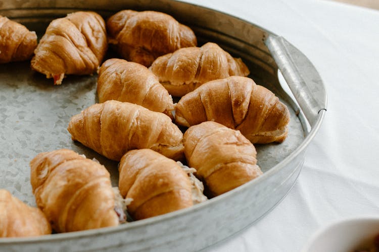 Tin Tray With Sweet Croissants On Table